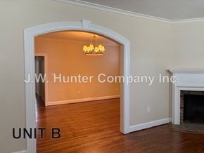 Wilson apartment for rent - A living room with a fireplace and a chandelier.
