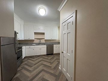 Wilson apartment for rent - A kitchen with white cabinets and a refrigerator.