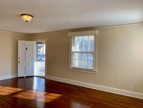 Wilson house for rent - an empty living room with wooden floors and a white door