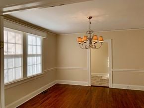 Wilson house for rent - an empty dining room with a chandelier and windows
