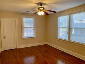 Wilson house for rent - a bedroom with a ceiling fan and two windows