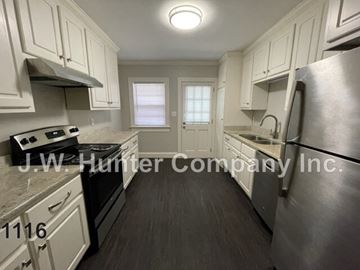 Wilson apartment for rent - A kitchen with white cabinets and a stainless steel refrigerator.