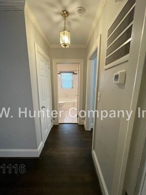 Wilson apartment for rent - A hallway with a light hanging from the ceiling and a door at the end.