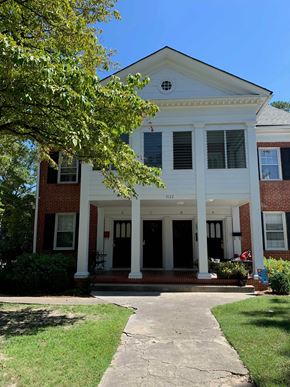 Wilson apartment for rent - A white house with a porch and a tree in front.