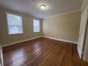 Wilson apartment for rent - A room with wooden floors and two windows.