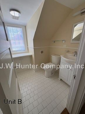 Wilson apartment for rent - A bathroom with a toilet, sink and window.