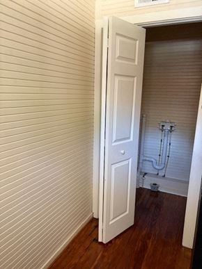 Wilson apartment for rent - A white door is open to a room with a white wall and a wooden floor.