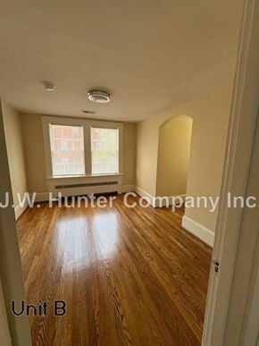 Wilson apartment for rent - A room with wooden floors and a window with blinds.