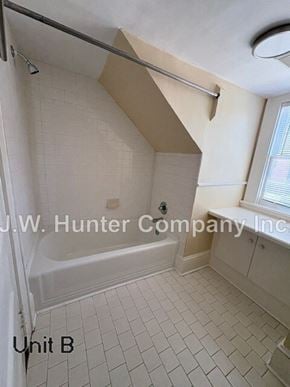 Wilson apartment for rent - A bathroom with a tub and a window.