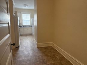 Wilson apartment for rent - A hallway with a tiled floor leads to a kitchen.