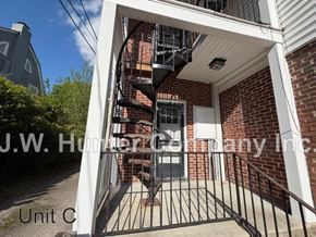 Wilson apartment for rent - A brick building with a white awning and a black gate in front.