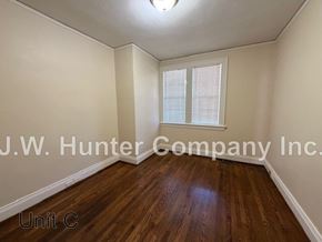 Wilson apartment for rent - A room with wooden flooring and white walls, with a window covered by white blinds.