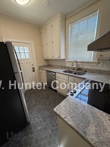 Wilson apartment for rent - A kitchen with a black fridge and a granite counter top.