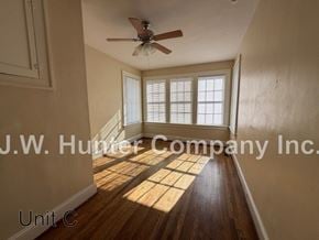 Wilson apartment for rent - A room with wooden floors and a ceiling fan.
