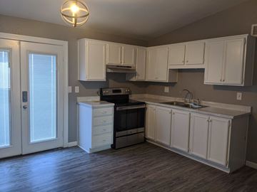 Phoenix house for rent - A kitchen with white cabinets and a wooden floor.