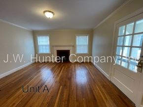 Wilson apartment for rent - A room with wooden floors and white walls, with a door on the right side.