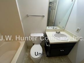 Wilson apartment for rent - A bathroom with a toilet, sink, and bathtub.