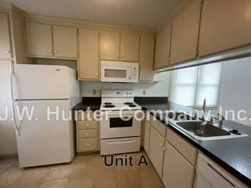 Wilson apartment for rent - A kitchen with white appliances and beige cabinets.