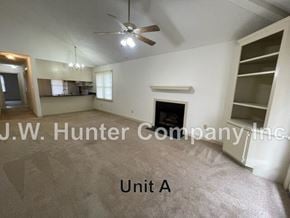 Wilson apartment for rent - A room with a fireplace and a ceiling fan.