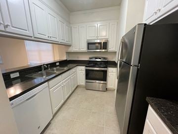 Rocky Mount apartment for rent - A kitchen with black countertops and white cabinets.