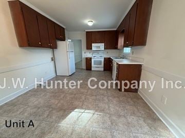 Wilson apartment for rent - A kitchen area with brown cabinets and a white refrigerator.