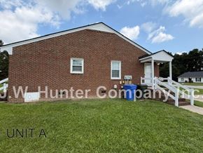 Wilson apartment for rent - A red brick building with a white fence in front.