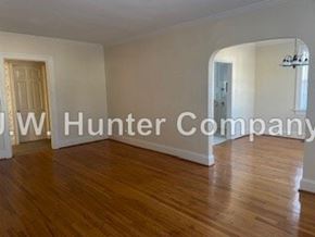 Wilson apartment for rent - A room with wooden floors and white walls, with a doorway leading to another room.