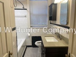 Wilson apartment for rent - A bathroom with a toilet, sink, and mirror.