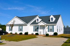Wake Forest apartment for rent - A white house with a black roof and a grey car parked in front.