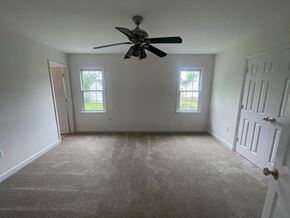 Wilson house for rent - A room with a ceiling fan and two windows.