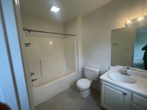 Wilson house for rent - A white bathroom with a toilet, sink, and bathtub.