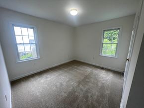 Wilson house for rent - A room with a carpeted floor and two windows.