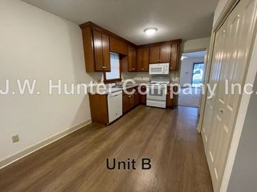 Wilson apartment for rent - A kitchen area with wooden cabinets and a microwave.