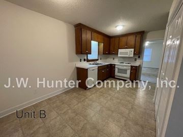 Wilson apartment for rent - A kitchen with white appliances and wooden cabinets.