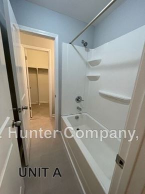 Wilson apartment for rent - A white staircase with a doorway leading to another room.