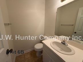 Wilson apartment for rent - A bathroom with a toilet, sink and mirror.