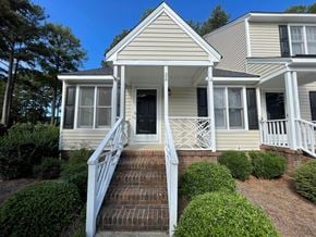 Wilson apartment for rent - A house with a white porch and a brown staircase leading to the front door.