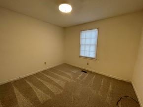 Wilson apartment for rent - A room with a carpeted floor and a window.