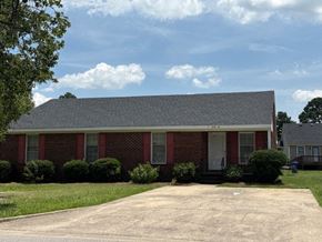 Wilson apartment for rent - A red brick house with a grey roof and a white door.