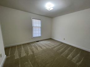 Wilson apartment for rent - A room with a carpeted floor and a window with blinds.