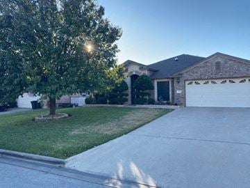 Killeen house for rent - a house with a driveway and a tree in front of it