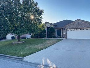 Killeen house for rent - a house with a driveway and a tree in front of it