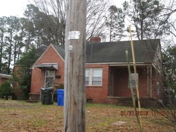 Wilson house for rent - a brick house with a wooden pole in front of it