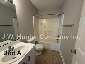Wilson apartment for rent - A bathroom with a sink, toilet, and bathtub.