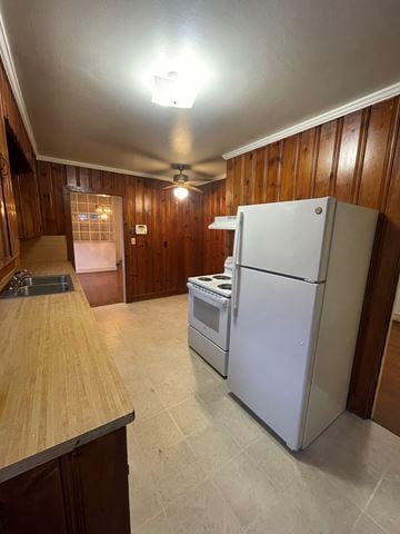 Wilson house for rent - A white refrigerator is in a kitchen with wooden walls.