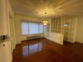 Wilson house for rent - A room with wooden floors and a chandelier hanging from the ceiling.