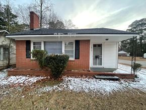 Wilson house for rent - A small house with a red brick chimney and a grey roof.