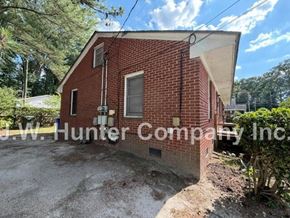 Wilson apartment for rent - A red brick building with a white sign that reads "J.W. Hunter Company Inc." in front of it.