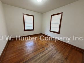 Wilson apartment for rent - A room with wooden floors and two windows.