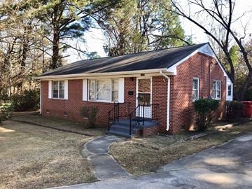 Wilson house for rent - a small brick house with a front porch and a black staircase